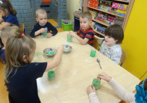 Dzieci barwią roztwór z soli na zielono.